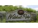Wildcat Ridge community sign with stone accents and lush greenery in the background at 10538 Tiger, Lone Tree, CO 80124