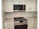 Modern kitchen features stainless steel appliances, light countertops, neutral backsplash and white cabinetry at 10538 Tiger, Lone Tree, CO 80124