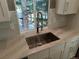 Modern kitchen sink features stainless steel fixtures, light countertops, neutral backsplash and a bright window view at 10538 Tiger, Lone Tree, CO 80124