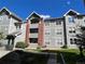 Attractive condo building with gray siding, brick accents, and well-maintained landscaping at 14201 E 1St Dr # 104, Aurora, CO 80011