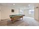 Spacious finished basement featuring a billiard room with carpet flooring and natural light from windows at 19372 E 41St Ave, Denver, CO 80249