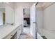 Bathroom featuring modern vanity and sink with a tub and shower and adjacent bedroom at 19372 E 41St Ave, Denver, CO 80249