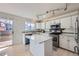 Bright kitchen features white cabinetry, an island, stainless steel appliances and a sliding door leading to a deck at 19372 E 41St Ave, Denver, CO 80249