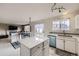 Kitchen featuring white cabinets, a center island with quartz countertops, and open sightlines to the living room at 19372 E 41St Ave, Denver, CO 80249