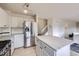 Well-lit kitchen with white cabinets, stainless steel appliances, quartz countertops, and a center island at 19372 E 41St Ave, Denver, CO 80249