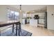 Bright kitchen featuring white cabinets, stainless steel appliances, a center island, and a sliding door to the deck at 19372 E 41St Ave, Denver, CO 80249