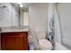 Cozy bathroom featuring a vanity with granite countertop, toilet and shower with a leaf-patterned curtain at 4971 Ceylon Way, Denver, CO 80249