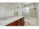 Modern bathroom with double vanity, granite countertop, tiled shower with glass door, and tiled walls at 4971 Ceylon Way, Denver, CO 80249