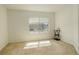 Sunny carpeted bedroom with large window and minimal furnishings with natural light at 4971 Ceylon Way, Denver, CO 80249