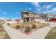 Well-manicured two-story home with solar panels, features an expansive front yard and a three car attached garage at 4971 Ceylon Way, Denver, CO 80249