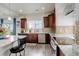 Modern kitchen features stainless steel appliances, tile backsplash, granite counters, and dark wood cabinets at 4971 Ceylon Way, Denver, CO 80249