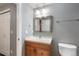 Basement bathroom with wood vanity and toilet at 63 Harrison St, Denver, CO 80206