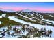 Expansive aerial shot captures a luxurious log home near a ski resort with ski slopes and snow-covered mountains at 422 Timber Trail Rd, Breckenridge, CO 80424