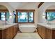 Luxurious bathroom with soaking tub, dual sinks, and a large window showcasing scenic views at 422 Timber Trail Rd, Breckenridge, CO 80424