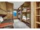 Rustic bunk room with wooden accents features multiple built-in bunk beds with individual ladders and a daybed at 422 Timber Trail Rd, Breckenridge, CO 80424