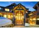 Front entrance of a rustic mountain home with stone columns and a wood framed doorway at 422 Timber Trail Rd, Breckenridge, CO 80424