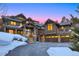 Elegant log home showcasing warm interior lighting, a heated driveway, and an inviting entrance framed by snow-covered landscaping at 422 Timber Trail Rd, Breckenridge, CO 80424