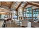 Cozy living room with stone fireplace, vaulted ceilings and large windows framing mountain views at 422 Timber Trail Rd, Breckenridge, CO 80424