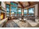 Bright living room with vaulted ceilings, stone fireplace, and scenic views from large windows at 422 Timber Trail Rd, Breckenridge, CO 80424