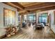 Open living and dining area features wood beams, a stone fireplace, and natural light from large windows at 422 Timber Trail Rd, Breckenridge, CO 80424
