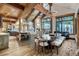 Bright living space featuring vaulted wood ceilings, stone fireplace, and dining area with large windows at 422 Timber Trail Rd, Breckenridge, CO 80424