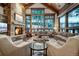Comfortable living room with stone fireplace and large windows with views at 422 Timber Trail Rd, Breckenridge, CO 80424