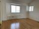 An unfurnished bedroom featuring wood floors and built-in seating beneath the large bright windows at 1339 Sumner St # B, Longmont, CO 80501