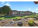 Rear view of home showcasing mature landscaping, stone creek bed and covered patio at 4719 Beverly Ln, Erie, CO 80516