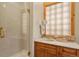 Bright bathroom features a glass enclosed shower, vanity, and natural lighting at 4719 Beverly Ln, Erie, CO 80516