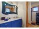 Unique bathroom with a blue vanity, custom mirror, and stylish fixtures next to the stand up shower at 4719 Beverly Ln, Erie, CO 80516
