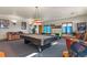 Spacious game room with a pool table, air hockey table, and comfortable seating area for entertainment at 4719 Beverly Ln, Erie, CO 80516