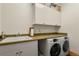 Well-organized laundry room with sink, counter space, and modern washer and dryer at 4719 Beverly Ln, Erie, CO 80516