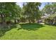 Expansive backyard featuring a lush lawn, mature trees, and inviting outdoor space at 6050 Marshall Ct, Arvada, CO 80003