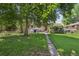 The backyard features a well-maintained lawn, mature trees, and a convenient walkway at 6050 Marshall Ct, Arvada, CO 80003