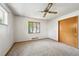 This bright carpeted bedroom offers a ceiling fan, a closet, and bright window views at 6050 Marshall Ct, Arvada, CO 80003