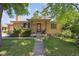 Charming brick home featuring a covered porch and well-maintained front yard at 6050 Marshall Ct, Arvada, CO 80003
