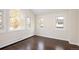 Sun-filled bedroom featuring dark hardwood floors and multiple windows at 521 N Fairfax St, Denver, CO 80220
