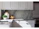Close-up of a modern kitchen with white cabinets, stainless steel appliances, and stylish backsplash at 521 N Fairfax St, Denver, CO 80220