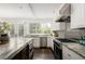 Well-lit kitchen features granite countertops, stainless steel appliances, and French doors leading outside at 521 N Fairfax St, Denver, CO 80220