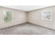 Bright bedroom with neutral walls and gray carpet, featuring two windows for natural light at 4896 S Dudley St # 4-7, Littleton, CO 80123
