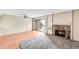 A sunny living room with hardwood floors, sliding doors to balcony, and a stone fireplace at 4896 S Dudley St # 4-7, Littleton, CO 80123