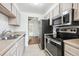 Galley kitchen with stainless steel appliances and view into entryway at 384 S Ironton St # 413, Aurora, CO 80012