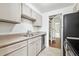 Galley kitchen with stainless steel dishwasher, white cabinets, and tile flooring at 384 S Ironton St # 413, Aurora, CO 80012
