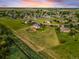 Expansive aerial view of the property with lush green lawn and neighborhood, enhanced by colorful sky at 17635 Silver Fox Ct, Mead, CO 80542