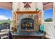 Close up of stone fireplace with decor, wood mantle, windows, and carved chair at 17635 Silver Fox Ct, Mead, CO 80542