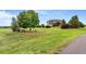 Well maintained front yard features mature landscaping, mature trees, and lush green grass at 17635 Silver Fox Ct, Mead, CO 80542