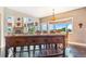 Dining room and kitchen view of island with seating, window and fireplace beyond at 17635 Silver Fox Ct, Mead, CO 80542