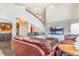 Comfortable living room featuring a large leather sofa and an open view to the dining area at 17635 Silver Fox Ct, Mead, CO 80542