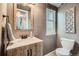 Charming bathroom features wooden vanity with brushed bronze fixtures, decorative mirror and toilet at 11481 King St, Westminster, CO 80031