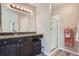 Bathroom features a dark vanity with granite countertop, framed mirror, and a glass shower stall at 11481 King St, Westminster, CO 80031